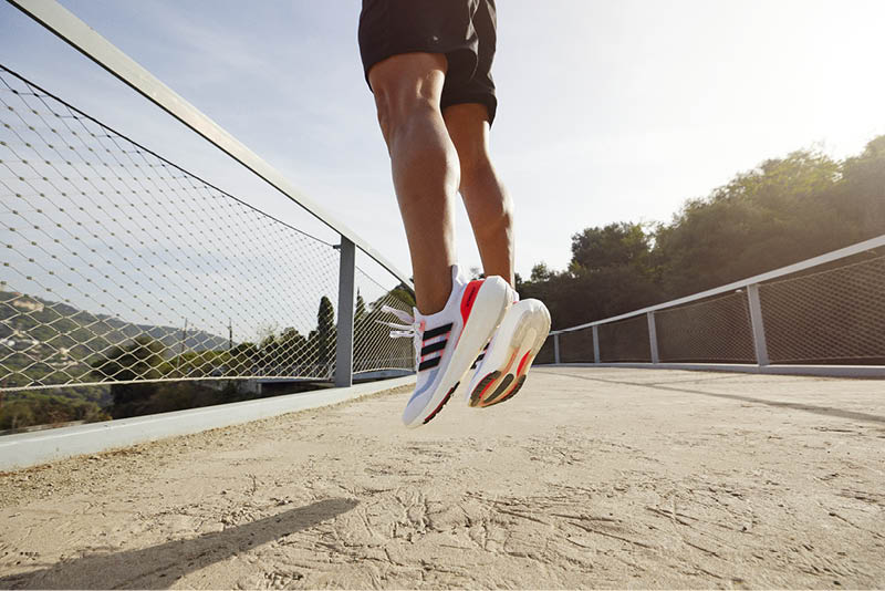 man jumping in adidas ultraboost light shoes wearing black athletic shorts