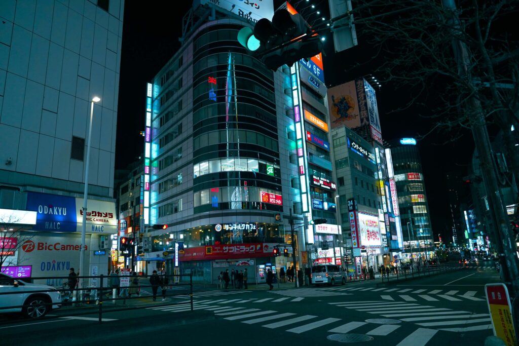 tokyo street at night with tall buildings and bright lights