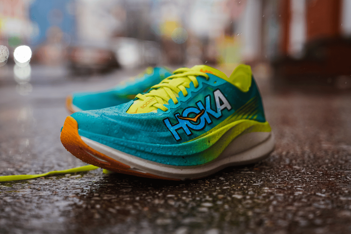 blue teal and yellow hoka rocket x 2 on a wet sidewalk