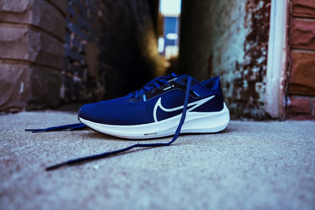 navy blue nike pegasus in an alleyway doorway