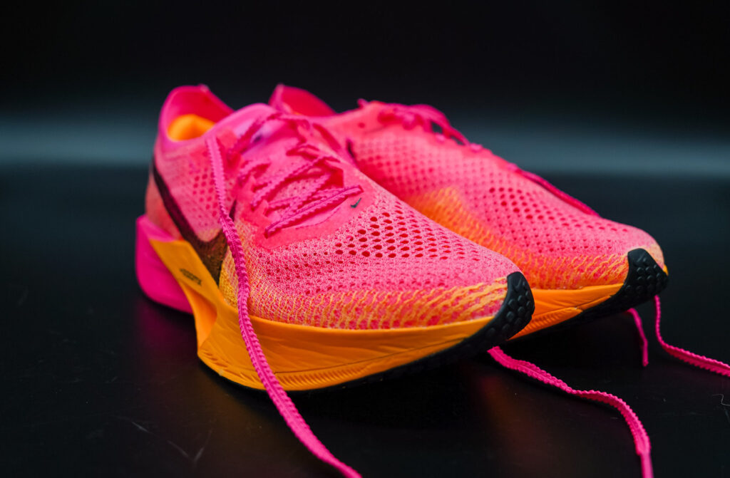 toes of pink and orange nike vaporfly next% 3 on a black table
