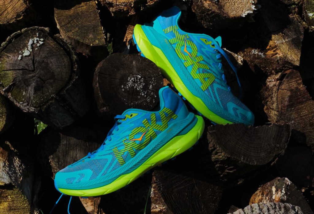 two hoka tecton x shoes in blue on a pile of wood logs