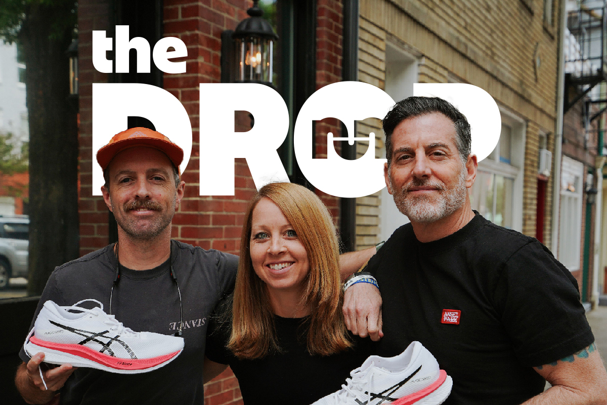 man on right holding an asics shoe, woman in the middle, man on left holding a white asics running shoe