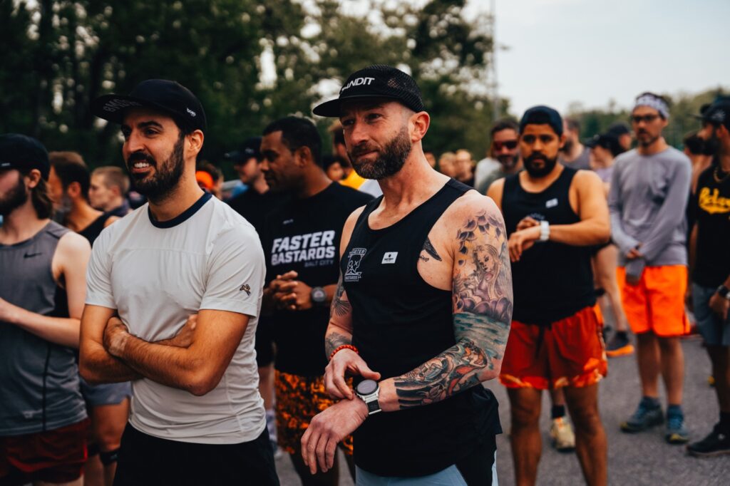 man with tattoos in a blank tank top at a group run