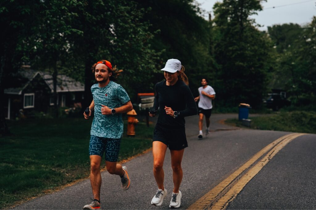 man and woman running on a road