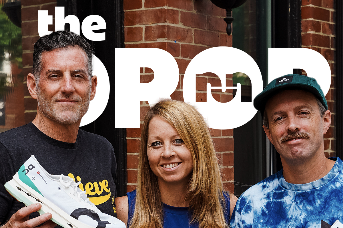 man holding an on racing shoe on left, woman smiling in the middle, man with tie dye shirt on right and a mustache