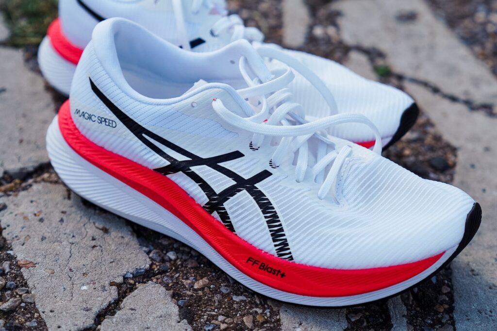 white asics shoe from above on pavement