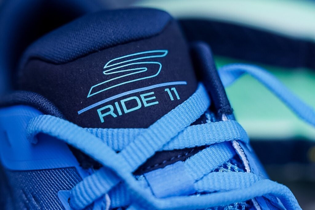 shoe tongue with skechers logo and words ride 11 with light blue laces