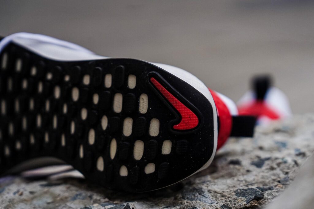 A close up of a nike air presto sneaker on a rock.