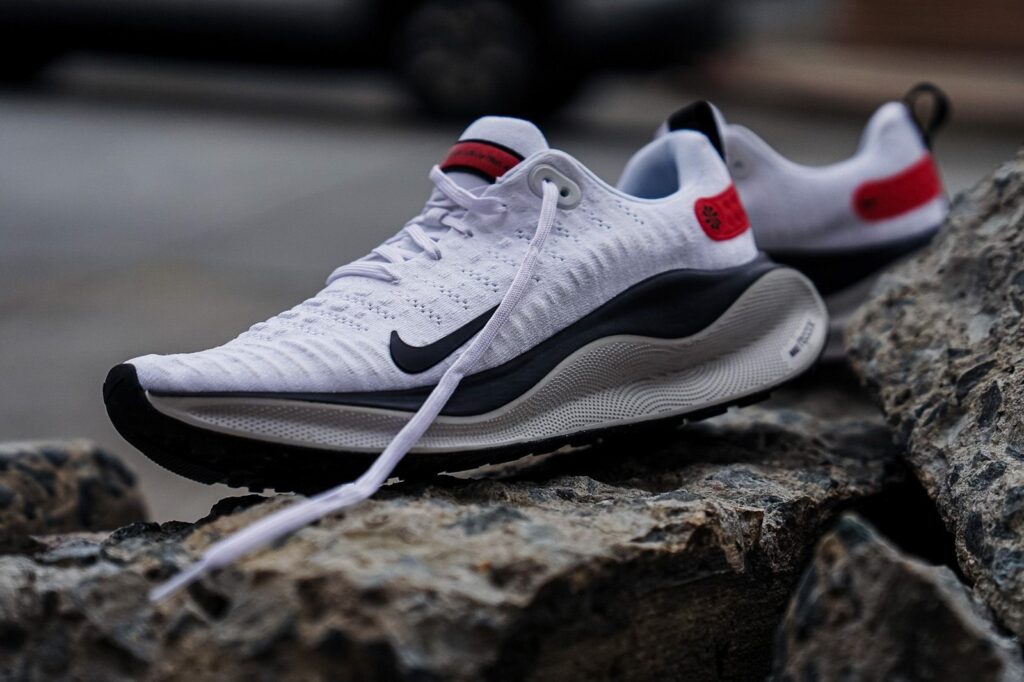 The nike air zoom flyknit is sitting on a rock.