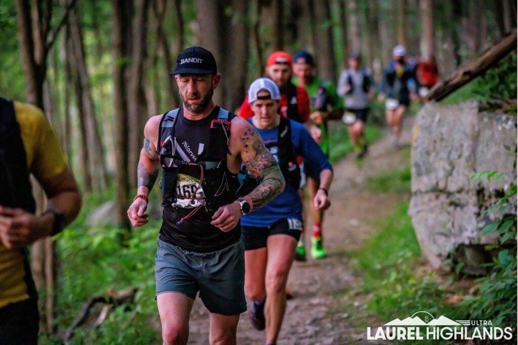 man running on trail with other people
