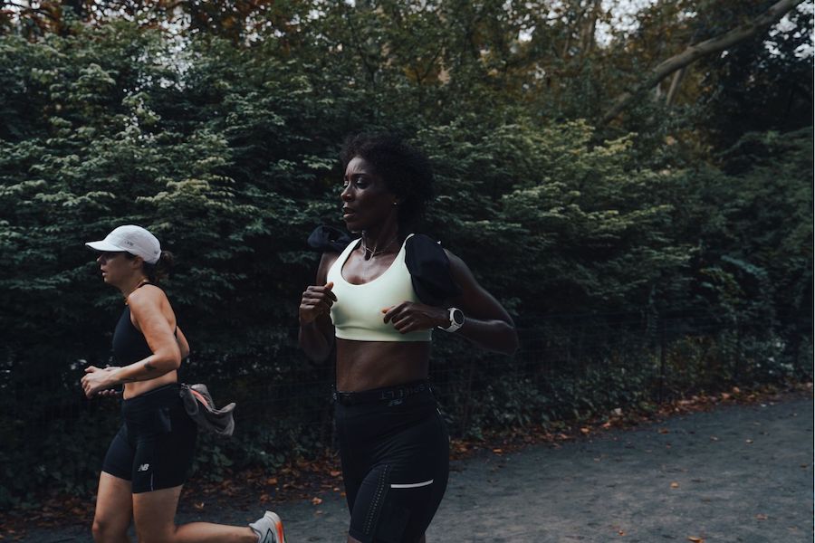 woman running with bushes in background