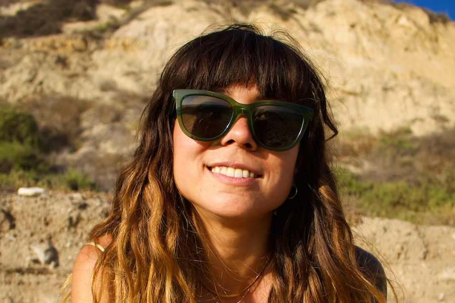Woman smiling, wearing green Article One sunglasses