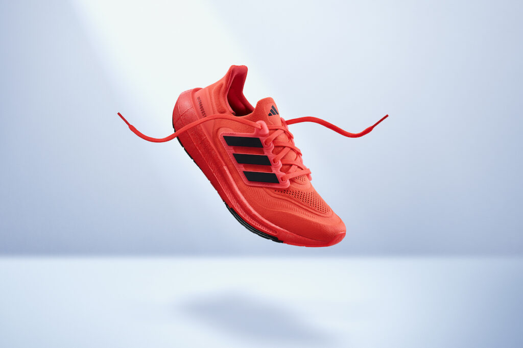 red adidas ultraboost light shoe on white background