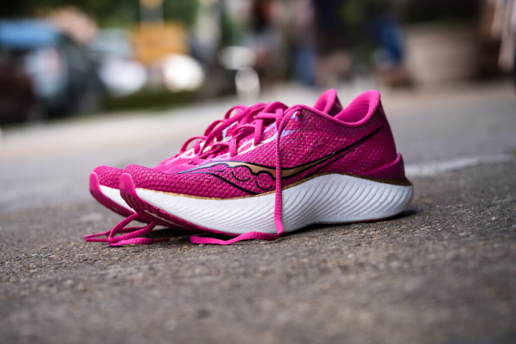 a pink saucony endorphin pro on a sidewalk