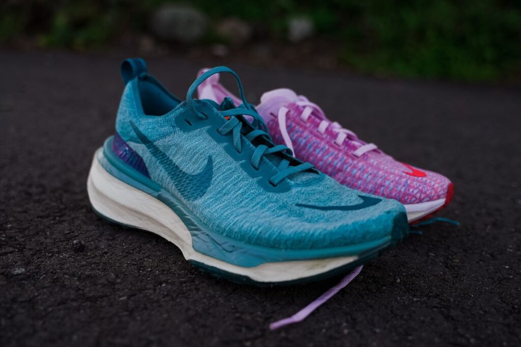 photo of the nike invincible 3 in men's blue colorway with a women's pink colorway behind it