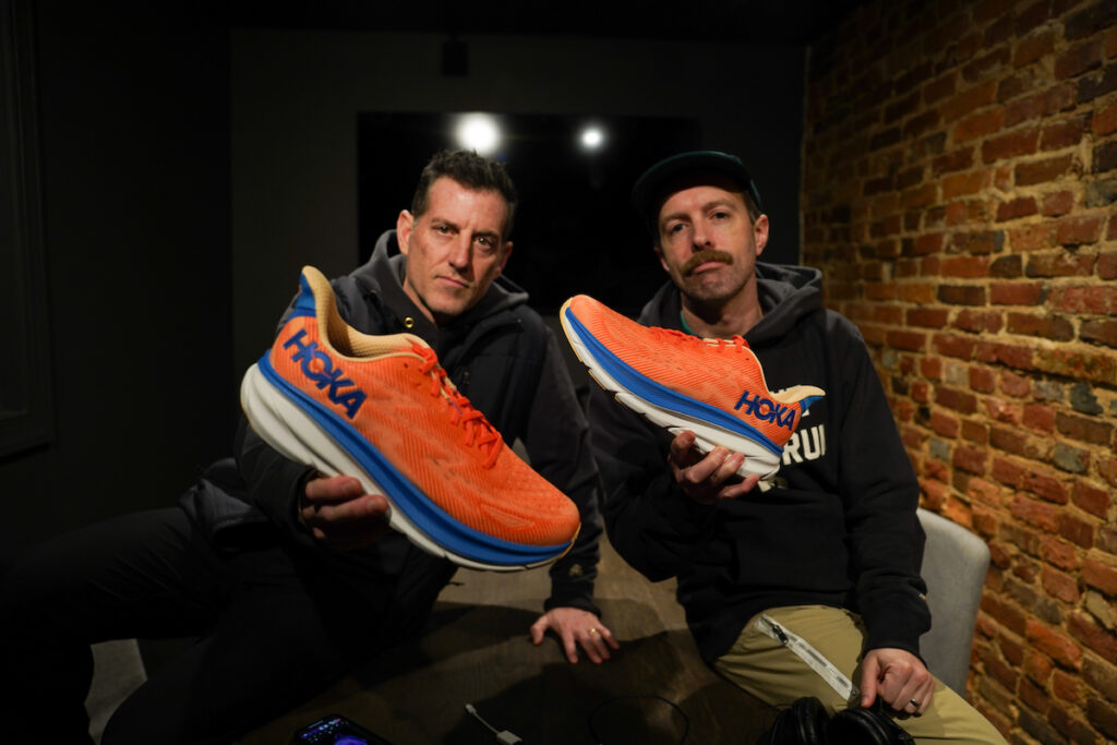 robbe and thomas of believe in the run holding a hoka clifton 9