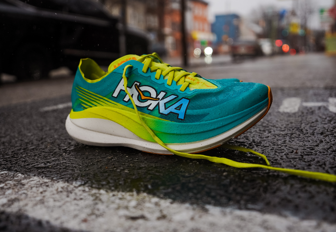 hoka rocket x 2 with teal and yellow upper with a city street in the background