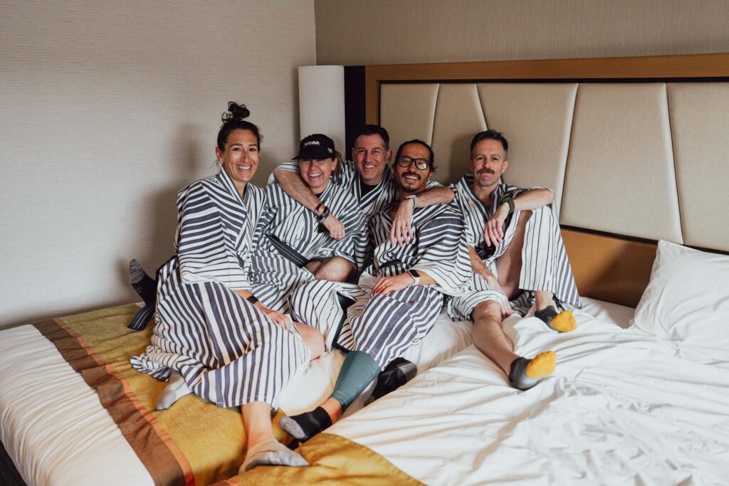 five people in robes sitting on a bed
