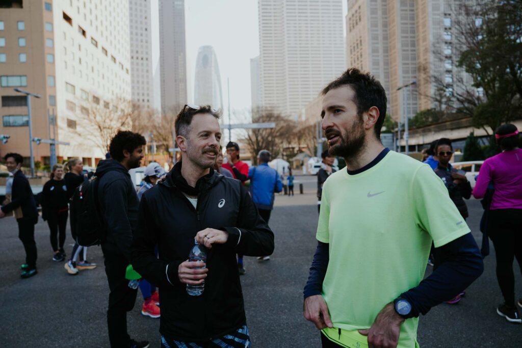 two men talking to each other in running clothes