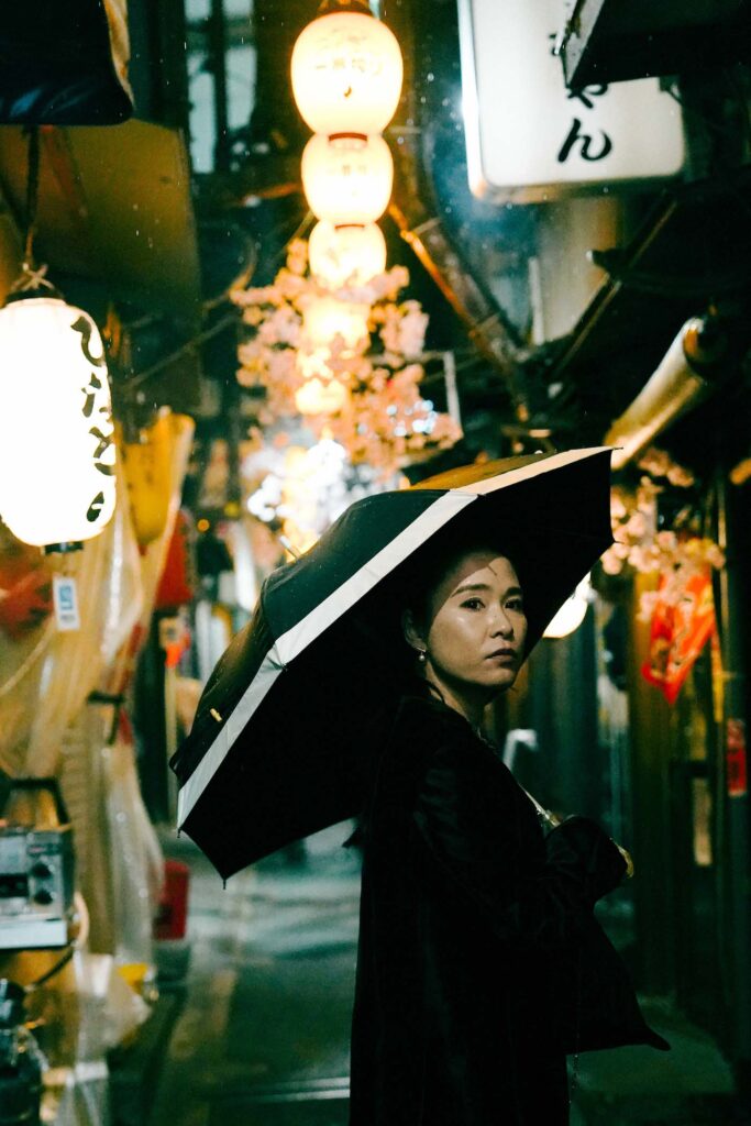 japanese woman holding an umbrella in tokyo at night