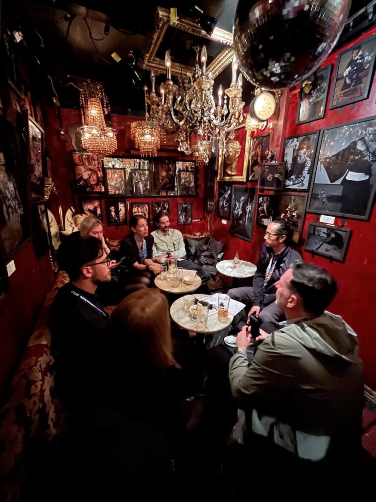 group of people sitting in a room of a bar upstairs