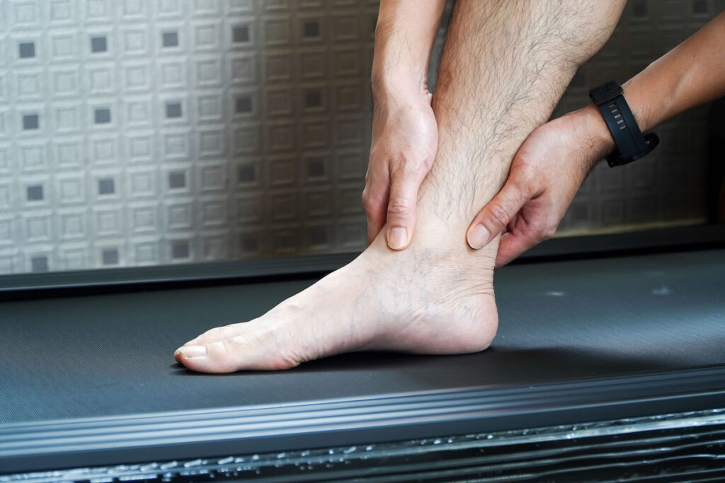 Man hurts his ankle while running on a treadmill,concept of not wearing shoes while running on a treadmill
