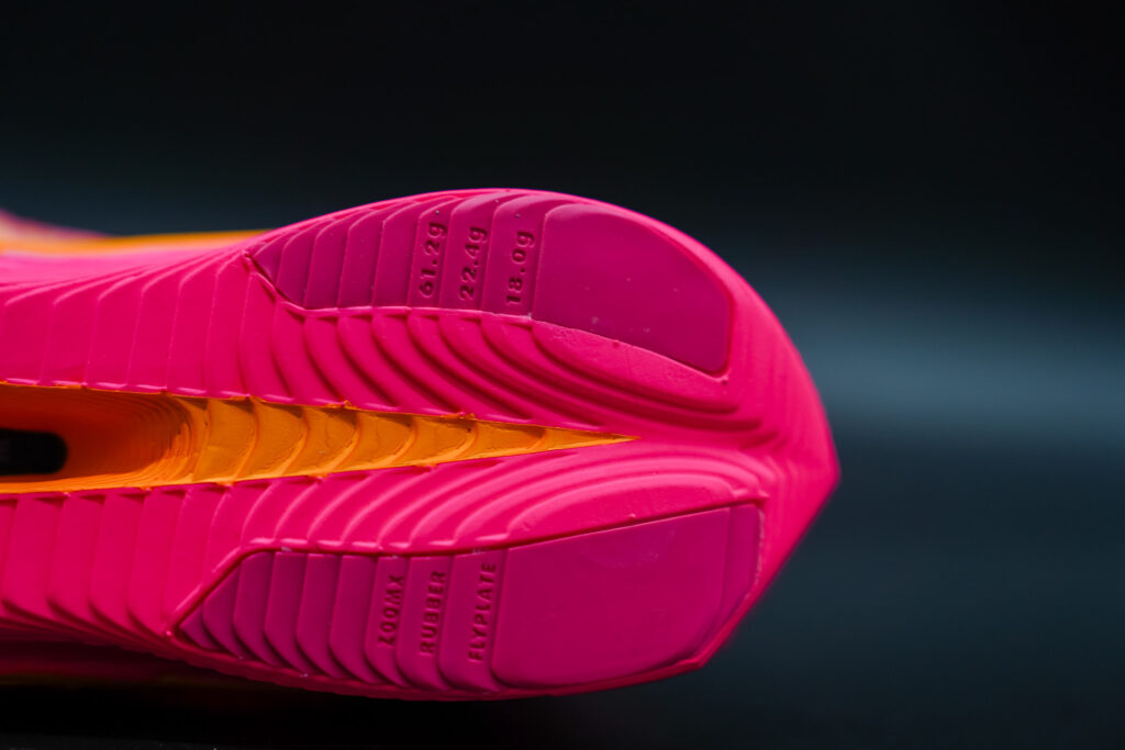 heel rubber of pink and orange nike vaporfly next% 3 on a black table