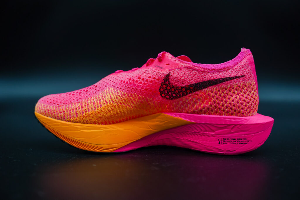 medial side of a pink and orange nike vaporfly next% 3 on a black table