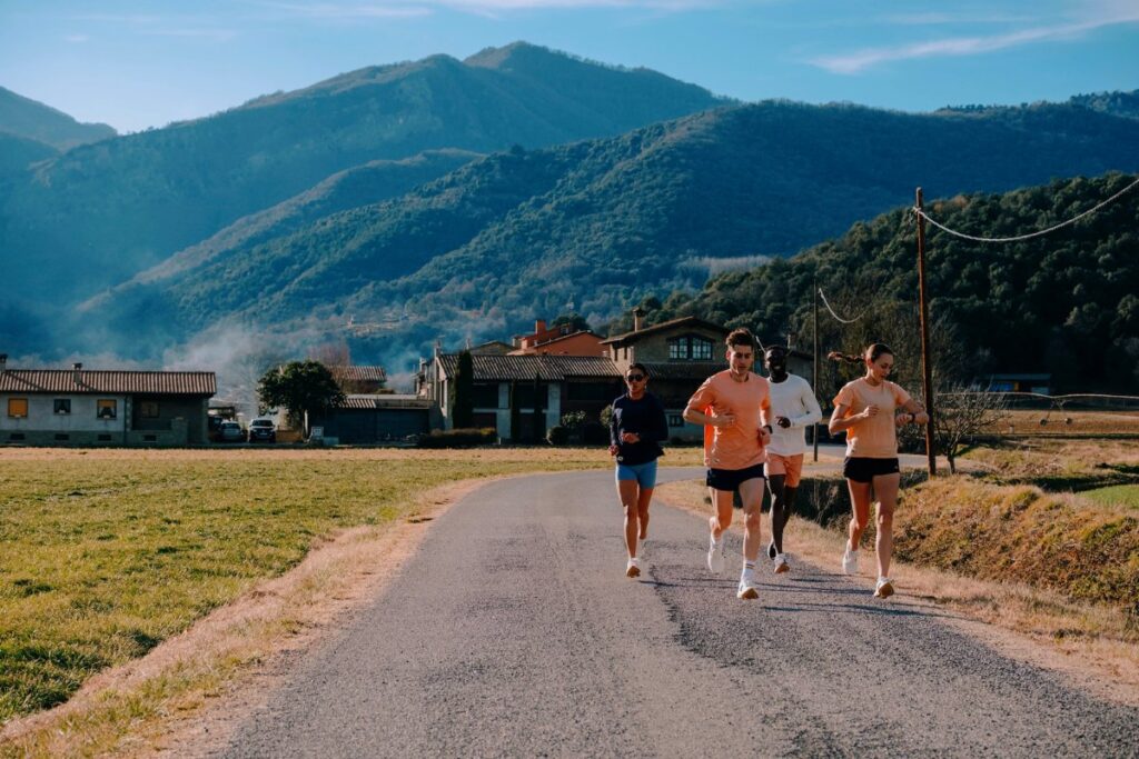 runners running down a country road in Spain with the mountains in the background