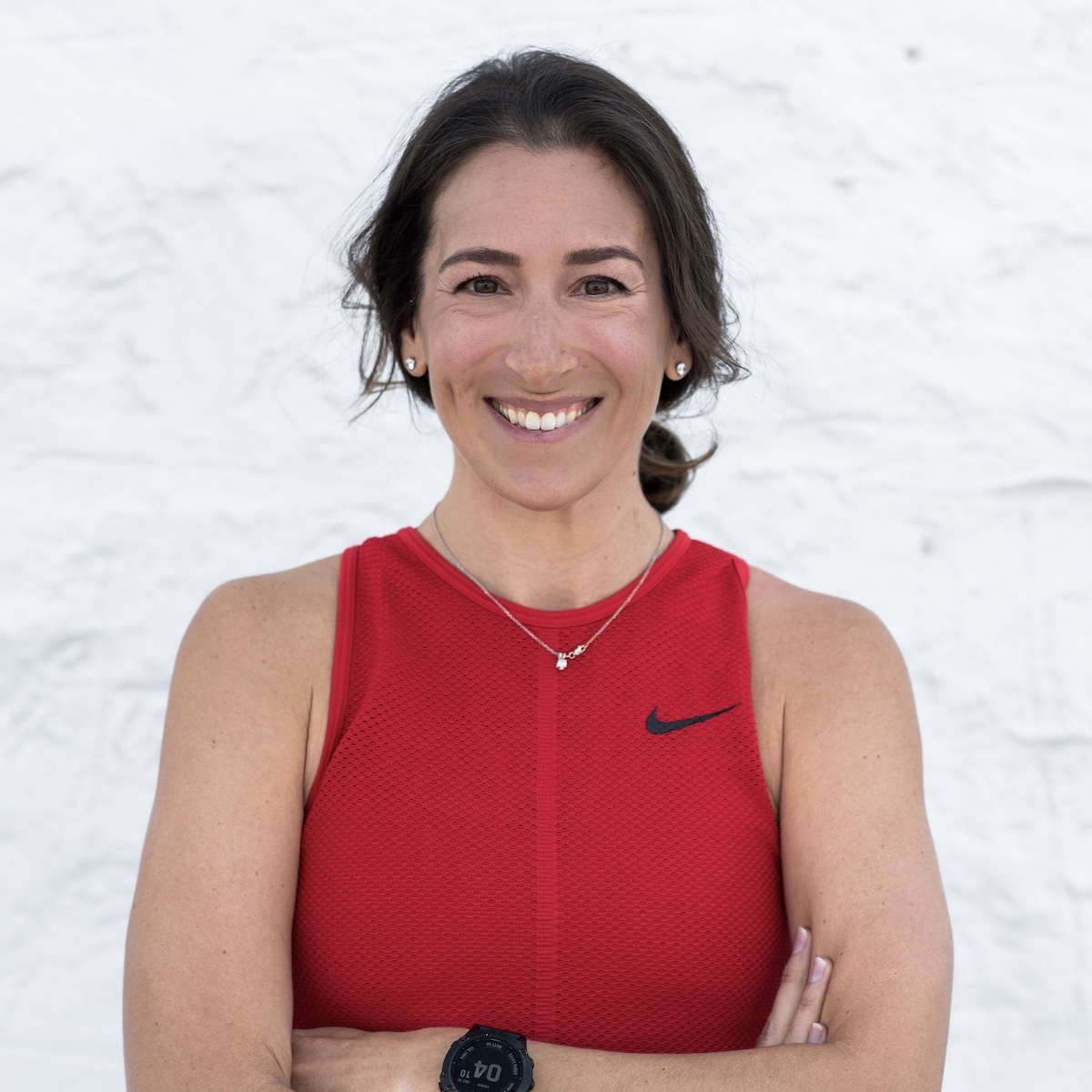 woman with brown hair in red nike top smiling