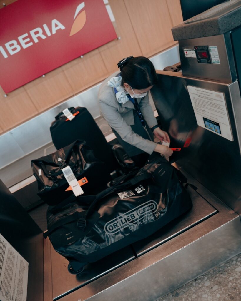 gate check-in person weighing luggate at an airport