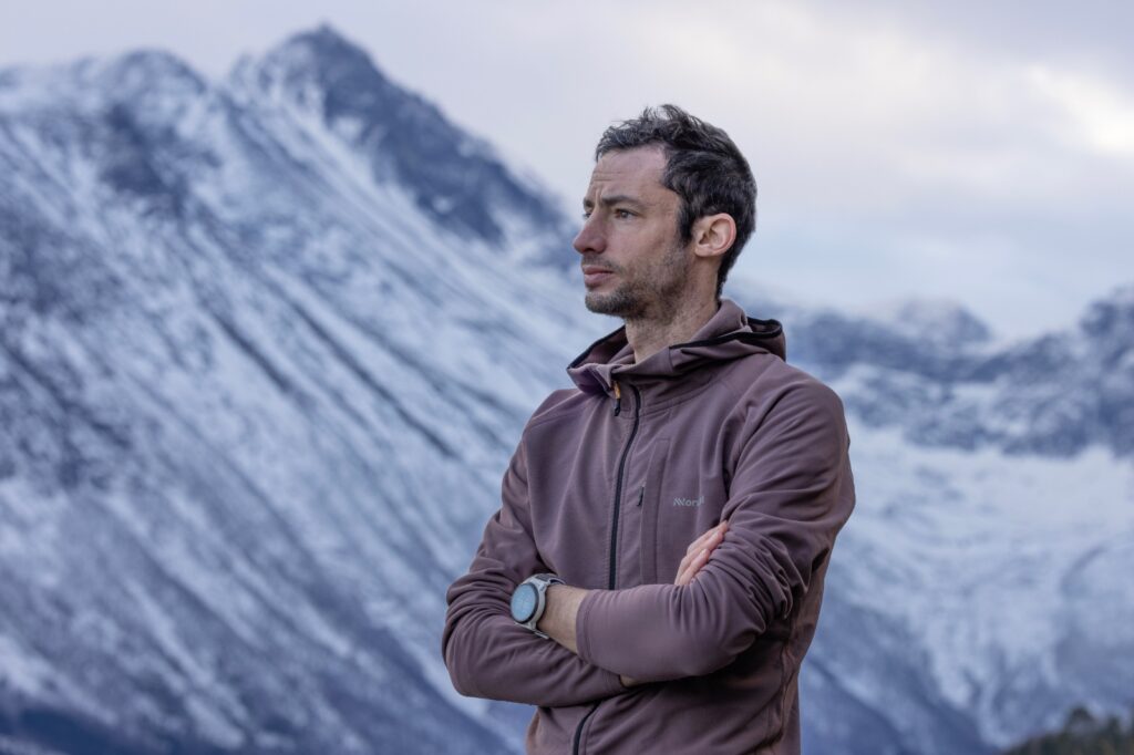 man looking into distance with snow-capped mountains in background