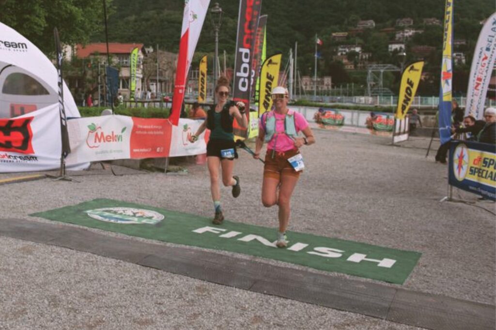 two women crossing a finish line at a race in Italy