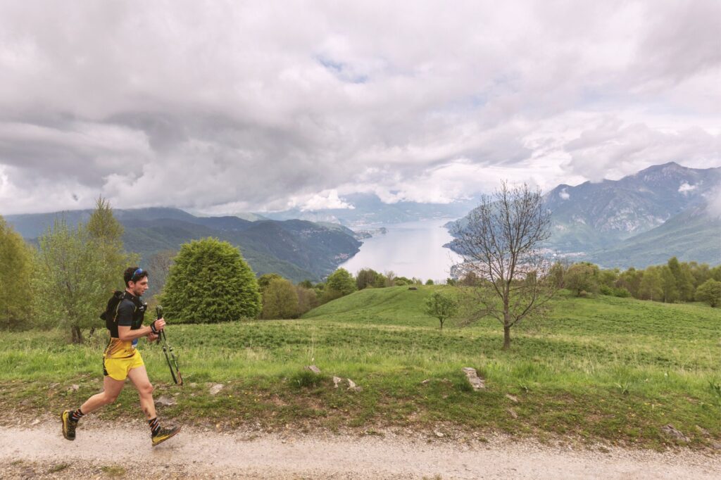 man running on a dirt road above Lake Como in Italy