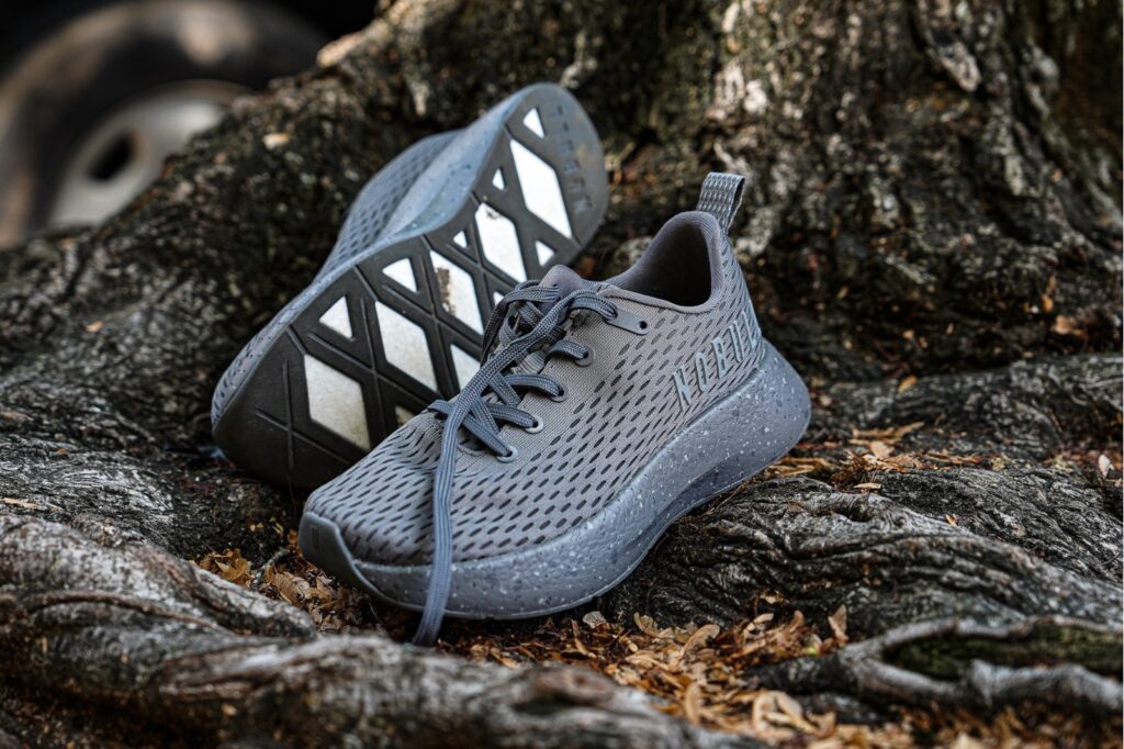 grey nobull shoes sitting on a root system of a tree