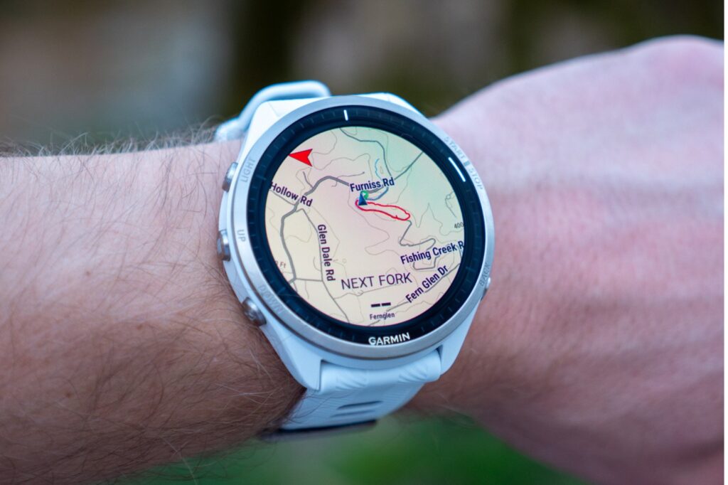 white garmin gps watch on man's wrist featuring a map