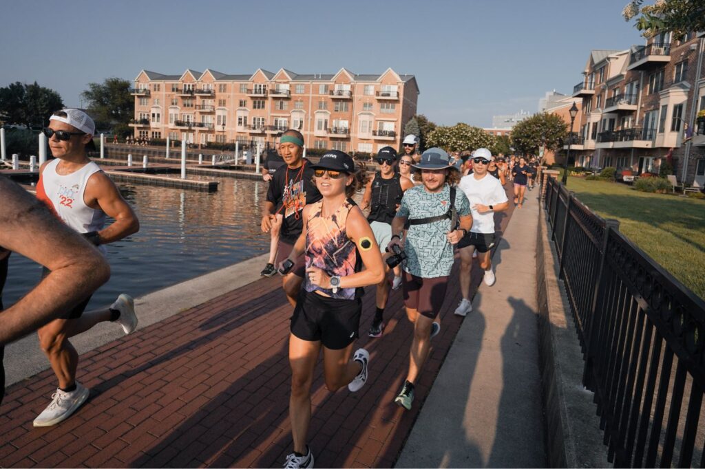A summer party recap with a group of people running along a sidewalk near a waterway.