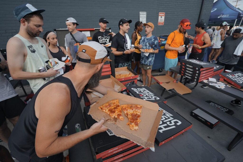 A summer party recap showcasing a group of people eating pizza at an outdoor event.