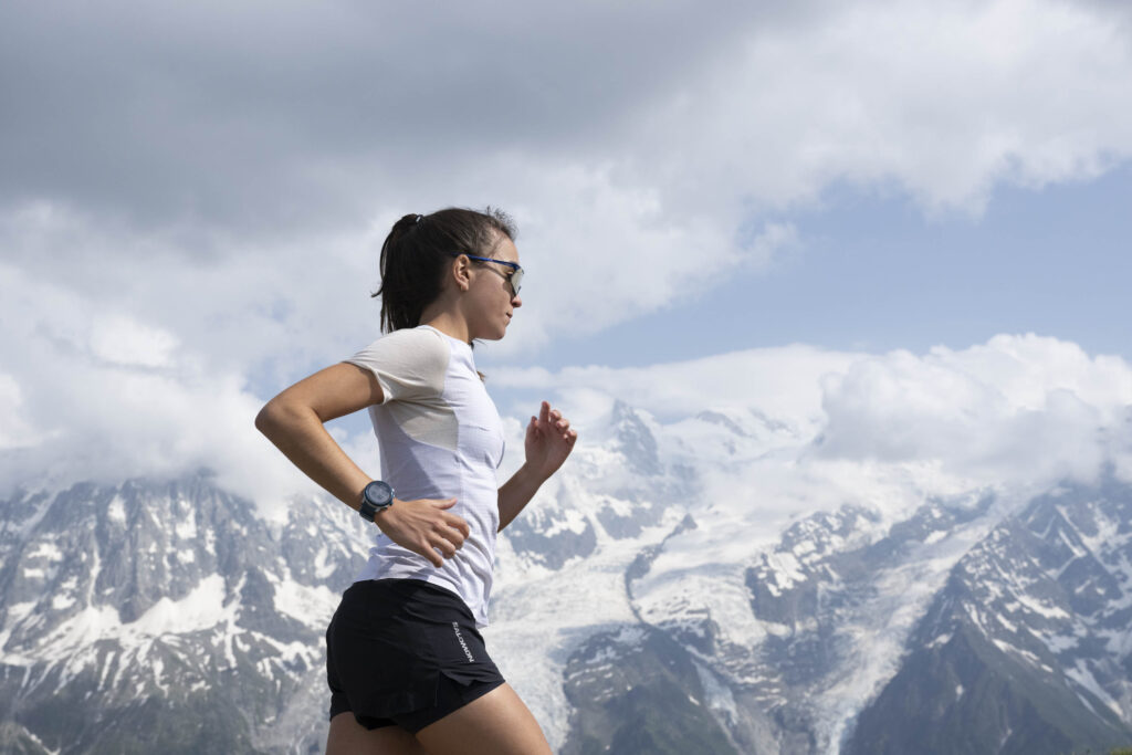 woman running with snow capped mountains in distance