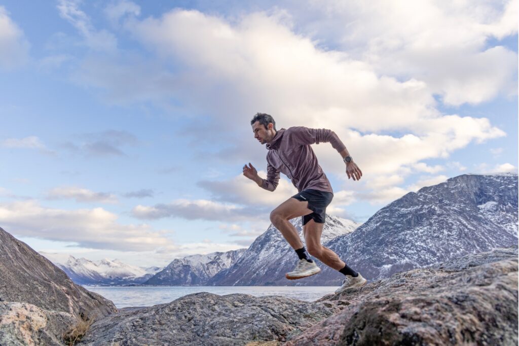 man running with mountains in background