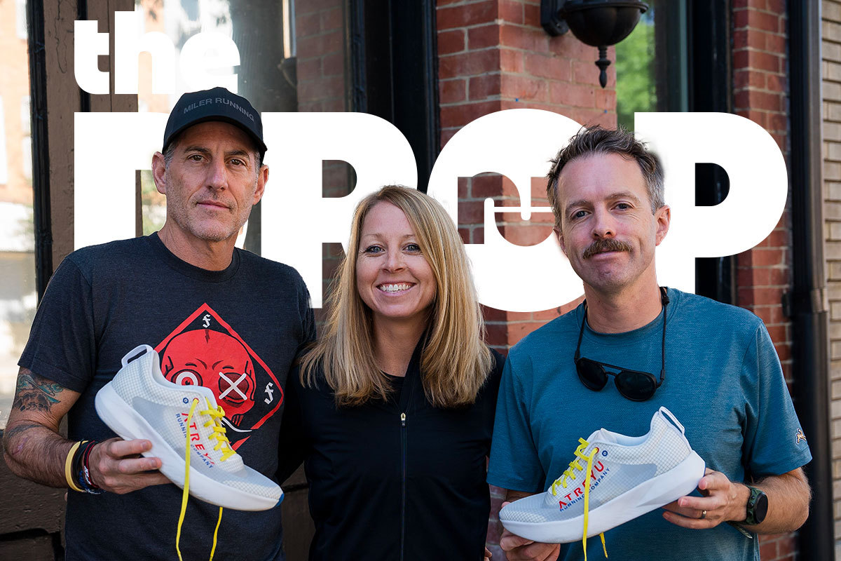man on right holding white running shoe, woman in center smiling, man on left with black hat holding white running shoe